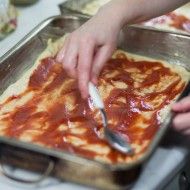 smarowanie ciasta na pizzę w formie sosem pomidorowym