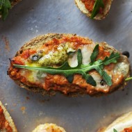 bruschetta ze świeżym pesto z bazylii oraz pulpą pomidorową ozdobiona listkiem rukoli