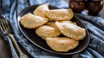 pieczone pierożki paszteciki z farszem z pieczarek rozłożone na talerzu